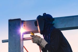 Worker welding parts of stell construction Worker welding parts of stell construction